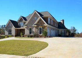 A driveway leading to a house with a roofing material pathway.