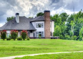 A house with right roof ventilation, located in the middle of a grassy field.