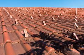 A commercial roof with red tiles and a blue sky.