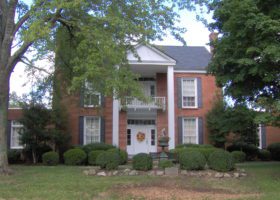 A red brick house with ways to keep the roof cool during the summers.