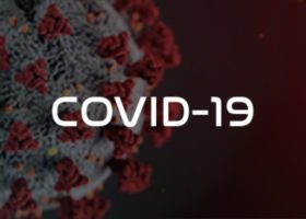 The impact of the Covid-19 pandemic on the roofing industry depicted through the word Covid-19 on a red background.