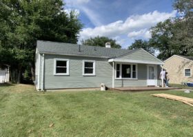 A house is being remodeled with new roof and siding, addressing wind damage.