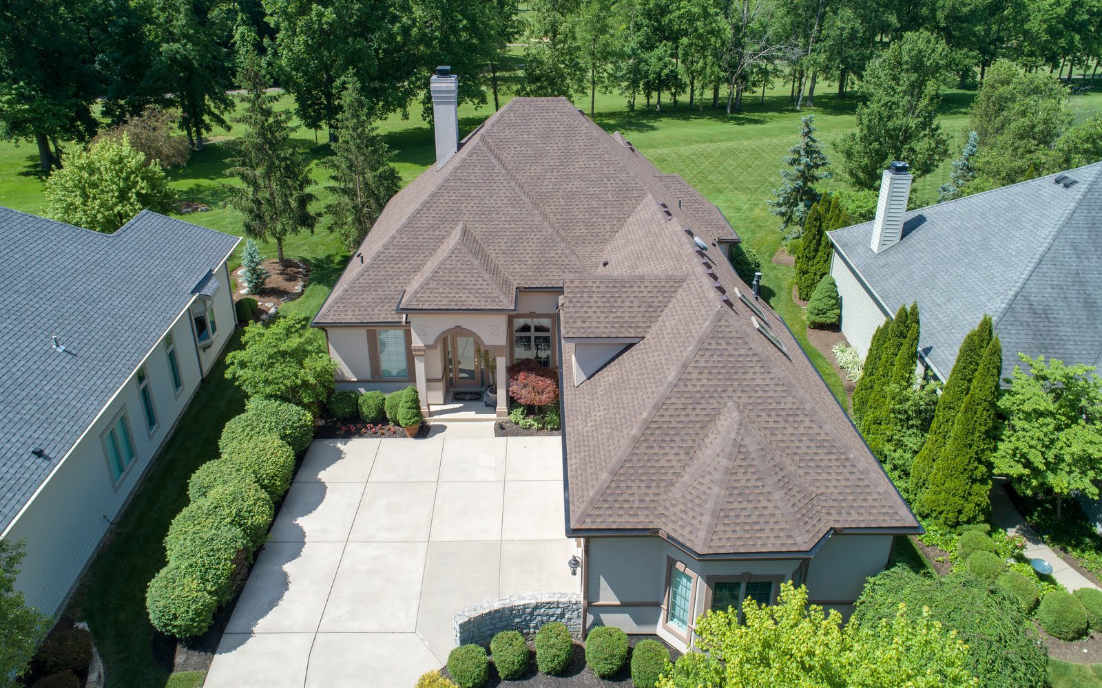 An aerial view of a home with a driveway and trees.