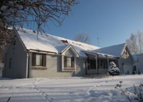 A house covered in snow after winterizing your roof.