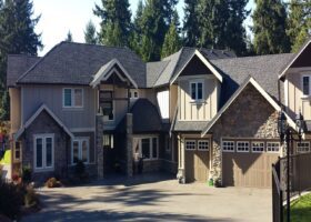 A leaky roof house with two garages and a driveway.