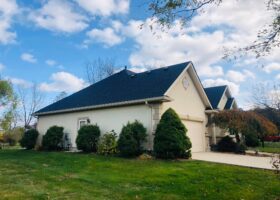 A house with a garage in front of it, perfect for DIY roofing.