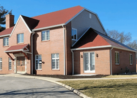 A brick home with a summer-ready red roof.