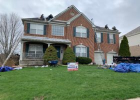 A group of men are working on a roof replacement job.