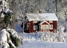 A red house with snow on the roof.